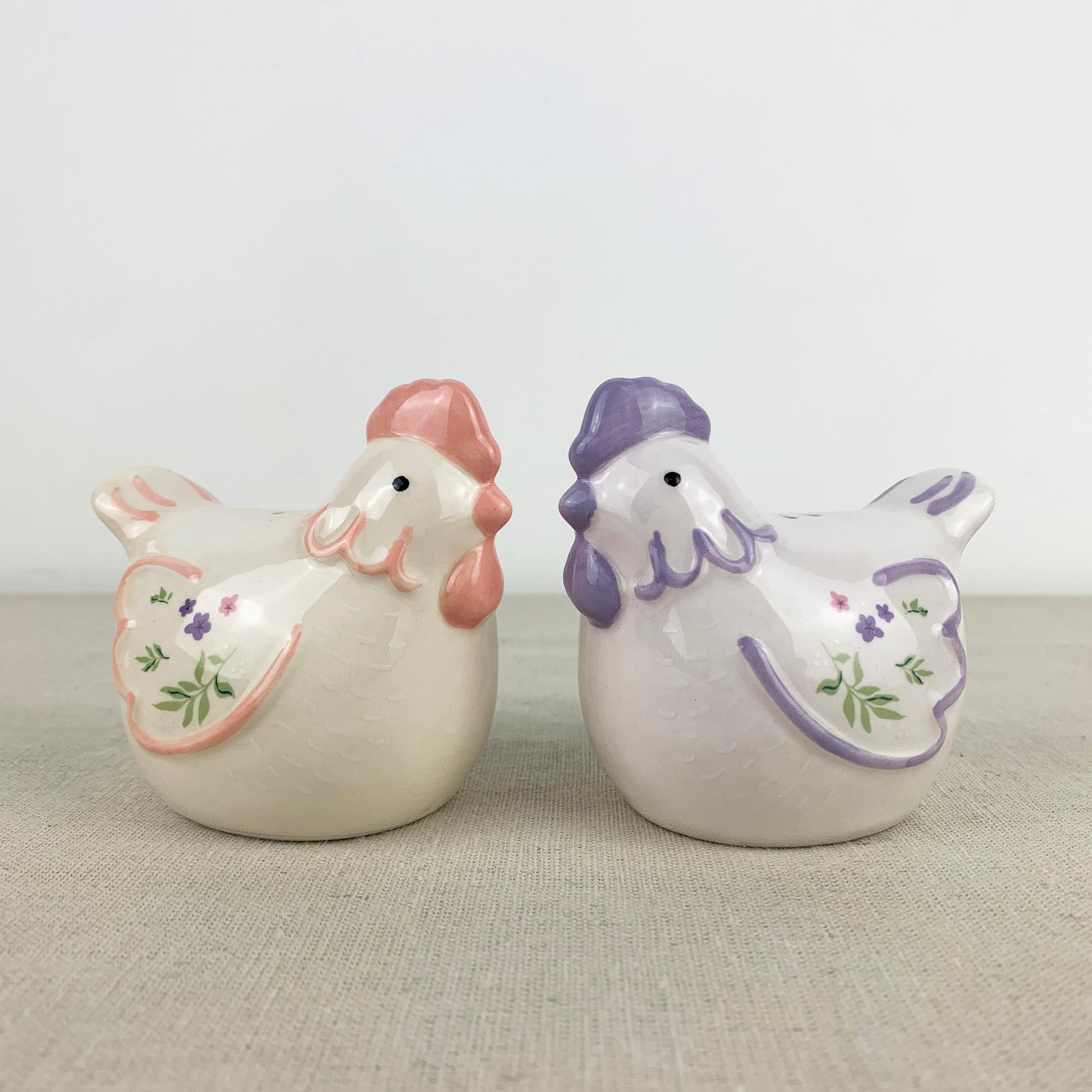 Two ceramic hen shakers with pastel colours