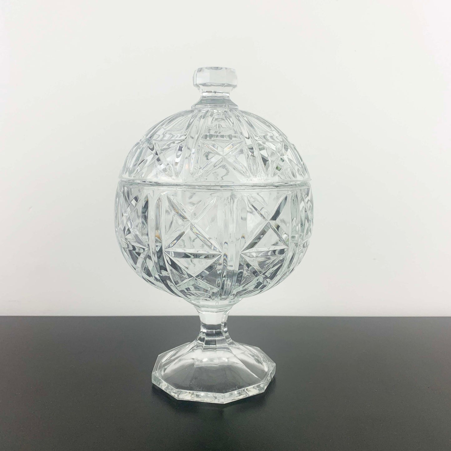 Crystal covered dish on a gray surface with a white background