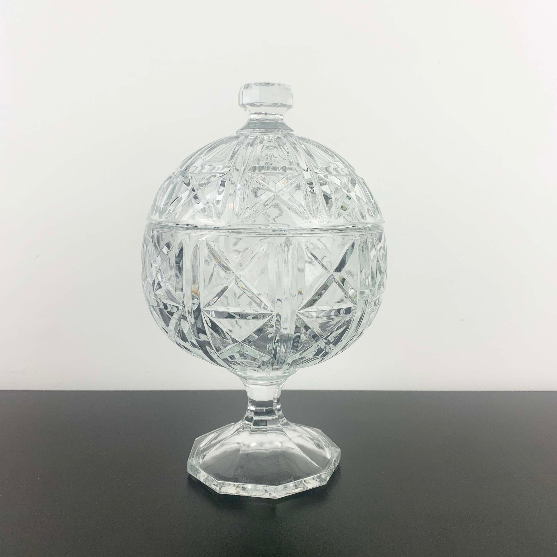 Crystal covered dish on a gray surface with a white background