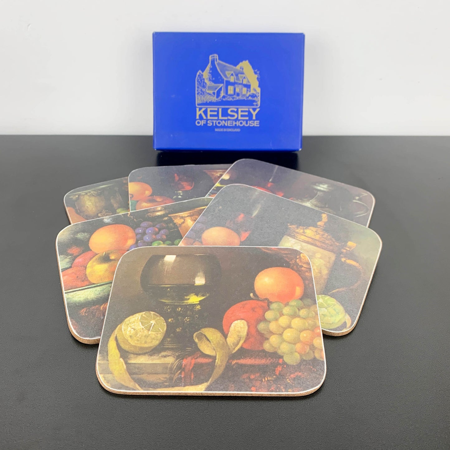 Set of coasters with fruit design in front of a Kelsey of Stonehouse box.