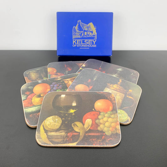 Set of coasters with fruit design in front of a Kelsey of Stonehouse box.
